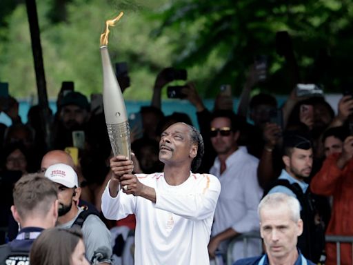 Snoop Dogg adds sizzle to Paris drizzle by carrying Olympic torch ahead of opening ceremony