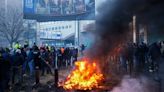 Firecrackers explode and thick smoke fills the air as seething farmers arrive at Brussels' door