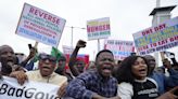 Police fire gunshots and tear gas as thousands protest Nigeria's crisis. Reports say 2 were killed