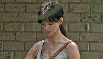 Anne Hathaway is spattered with fake blood as she brandishes fireplace poker while shooting scene for 'dinosaur movie' Flowervale Street