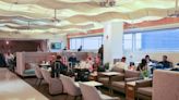 Let’s peek inside the Sky Club at Miami’s airport. We hear Celia Cruz and smell a buffet