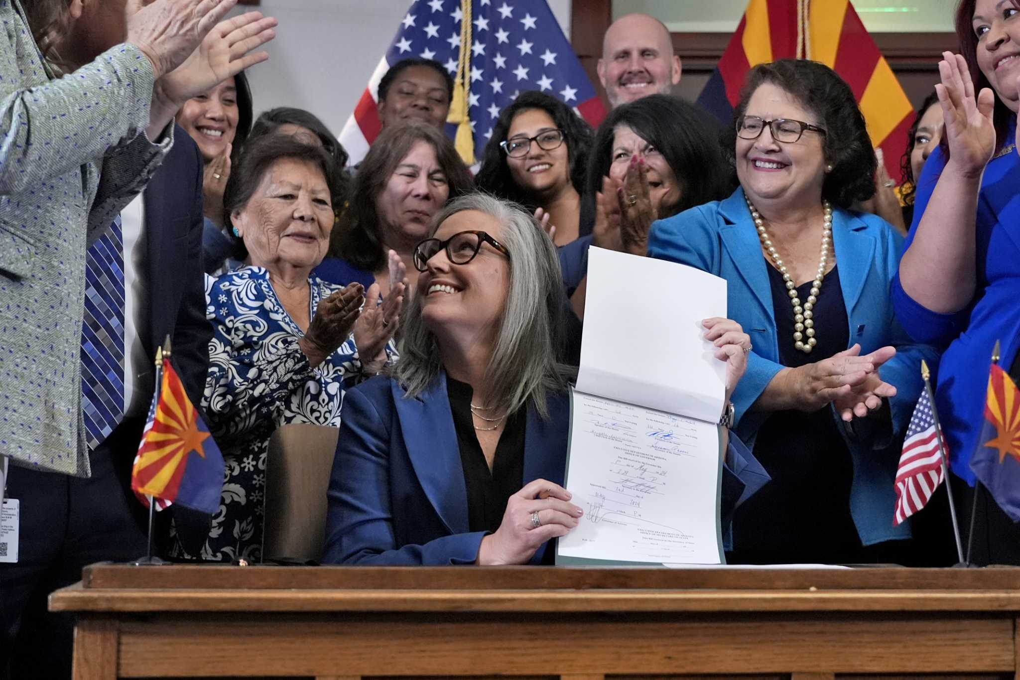 Arizona's Democratic governor signs a bill to repeal 1864 ban on most abortions