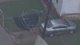 Storm blows trampoline into utility lines, suspending it midair outside home