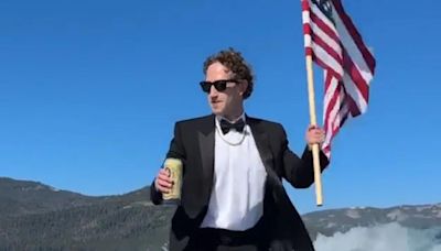 Mark Zuckerberg surfs while drinking beer, holding flag. Rival Elon Musk can’t resist snark