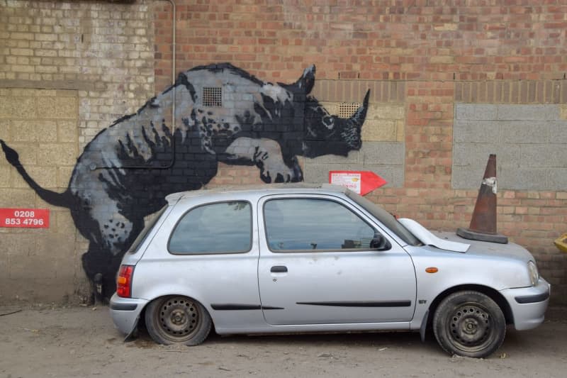 Banksy unveils artwork of rhino that appears to be mounting a car