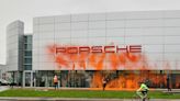 Cuatro activistas climáticos rocían un concesionario Porsche con pintura naranja en Suiza