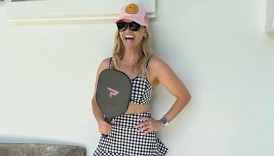 Reese Witherspoon flashes her toned abs in tennis co-ord