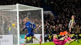 Newcastle goalkeeper Martin Dubravka confronted by a fan on the field at Chelsea