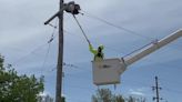 Ameren lineman removes Mylar balloons from a dead electrical pole