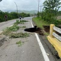 A damaged road in Venezuela after a river swelled due to heavy rains following Hurricane Beryl