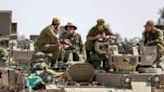 Israeli soldiers sit atop an infantry fighting vehicle near the border with the Gaza Strip on April 30, 2024