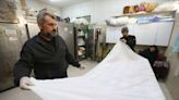 In Gaza, rows of white shrouds symbolise mounting civilian deaths