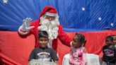 Santa Claus y duendes periodistas regalan juguetes a niños en Caracas