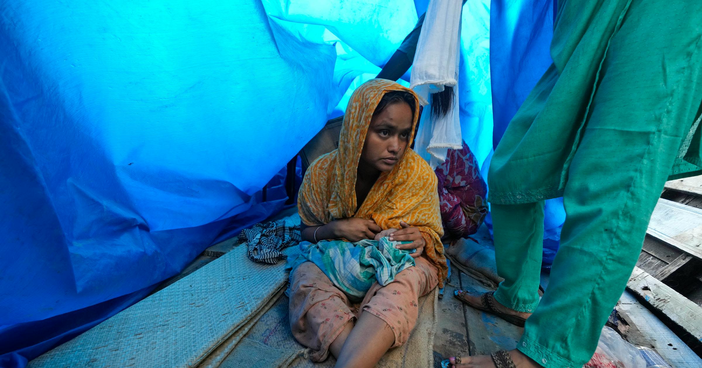 Indian mother delivers baby on boat as her river island is inundated by floodwaters