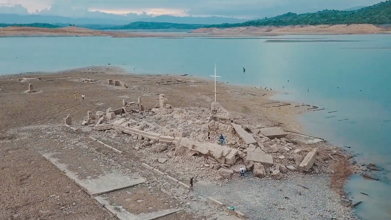  The image shows the ruins of the Pantabangan Sunken City, a town in the Philippines that was submerged in water after the construction of the Pantabangan Dam in 1979.