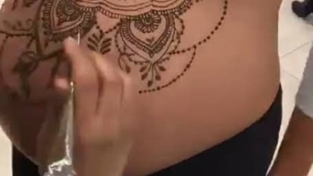 Henna tatoo on pregant belly A color photo of a henna tatoo on a womans  pregnant belly on yellow background  CanStock