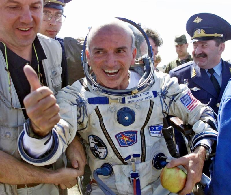 American multimillionaire Dennis Tito, 60, gestures shortly after his landing on the steppes, 80 kilometers (50 miles) northeast of Arkalyk, Kazakstan, Sunday, May 6, 2001. Others are unidentified. The Russian Soyuz capsule carrying the world's first paying space tourist landed successfully on Sunday, ending Tito's multimillion dollar cosmos adventure. (AP Photo/Mikhail Metzel)