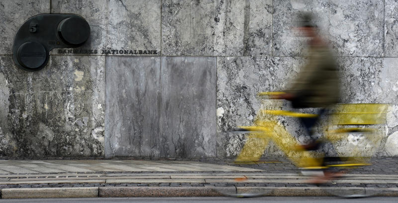 A cyclist passes the entrance of the Danish central bank, also known as Danish Nationalbank, in Copenhagen, January 22, 2015. The Danish central bank cut its key policy rate on Thursday for the second time this week to defend the crown's peg to the euro after the European Central Bank unveiled a stimulus package that weakened the single currency. REUTERS/Fabian Bimmer (DENMARK - Tags: BUSINESS)