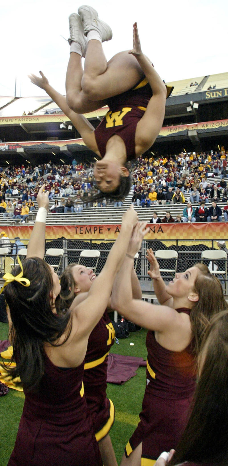 MARLIN LEVISON *mlevison@startribune.com 12/29/06 Assign# 107906- Minnesota Gophers vs. Texas Tech in Insight Bowl. Minnesota cheerleaders and marching band get in the spirit of the game with 'basket tosses' on the sideline while the band waves 'cheer sticks' from their stadium seats. IN THIS PHOTO: Cheerleader Katie Lund of Minneapolis is tossed in the air by teammates. (Photo by Marlin Levison/Star Tribune via Getty Images)