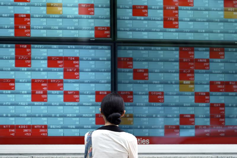 FILE - In this July 10, 2019, file photo a woman looks at an electronic stock board showing Japan's Nikkei 225 index at a securities firm in Tokyo. More and more government and even some corporate bonds are trading at negative interest yields. The negative yield phenomenon, 87% of it in Europe and Japan, is above all sign of pessimism about the future, or risk-off behavior in market jargon. (AP Photo/Eugene Hoshiko, File)