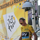 Britain's Christopher Froome, wearing the overall leader's yellow jersey, walks down the steps of the podium after signing the start list prior to the tenth stage of the Tour de France cycling race over 167 kilometers (103.8 miles) with start in Tarbes and finish in La Pierre-Saint-Martin, France, Tuesday, July 14, 2015. (AP Photo/Christophe Ena)