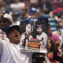 A man holds up a fight poster as fans wait for undefeated WBC/WBA welterweight champion Floyd Mayweather Jr. of the U.S. at the MGM Grand Arena in Las Vegas, Nevada April 28, 2015.  REUTERS/Las Vegas Sun/Steve Marcus