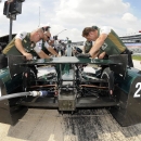 Crew members work on the car of Ed Carpenter (20) during a practice session for an IndyCar auto race at Texas Motor Speedway, Friday, June 5, 2015, in Fort Worth, Texas. IndyCar is mandating the use of closure panels on the rear wheel guards for the remaining three super speedway races. The decision is in response to three cars going airborne during preparation for the Indianapolis 500. (AP Photo/Larry Papke)