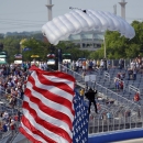 A United States flag, carried by a sky diver, arrives at the start/finish line at the IndyCar Series race at the Milwaukee Mile in West Allis, Wis., Sunday, July 12, 2015. (AP Photo/Jeffrey Phelps)