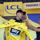 Team Sky rider Chris Froome of Britain celebrates as he wears the race leader's yellow jersey on the podium of the third stage of the 102nd Tour de France cycling race from Anvers to Huy, Belgium, July 6, 2015.  REUTERS/Eric Gaillard