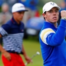 European Ryder Cup player Rory McIlroy (R) celebrates as he stands with U.S. Ryder Cup player Rickie Fowler after halving the hole on the 12th green during the 40th Ryder Cup singles matches at Gleneagles in Scotland September 28, 2014. REUTERS/Eddie Keogh/File Photo