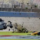 Ryan Briscoe flips through the infield grass in front of Ryan Hunter-Reay on Saturday June 27, 2015, during the IndyCar auto race at Auto Club Speedway in Fontana, Calif. (AP Photo/Will Lester)