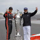 Juan Pablo Montoya, of Colombia, and his father, Pablo, poses with the Borg-Warner Trophy during the traditional winners photo session at Indianapolis Motor Speedway in Indianapolis, Monday, May 25, 2015. Montoya won the 99th running of the Indianapolis 500 auto race on Sunday. (AP Photo/Michael Conroy)