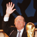 FILE - In this Monday June 8, 1998 file photo, Switzerland's Sepp Blatter next to a replica of the World Cup trophy, waves after being elected FIFA president, the world's soccer governing body, in Paris. FIFA has been routinely called 