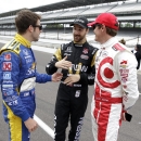 Marco Andretti, left, talks with Sage Karam, center, and Scott Dixon, of New Zealand, as they wait to pose for a group photo of the starting lineup before the start of practice for the Indianapolis 500 auto race at Indianapolis Motor Speedway in Indianapolis, Monday, May 18, 2015. (AP Photo/Michael Conroy)