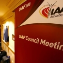 Journalists are seen near a logo of the International Association of Athletics Federations (IAAF) at a hotel where the IAAF council holds a meeting in Vienna, Austria, June 17, 2016.  REUTERS/Leonhard Foeger