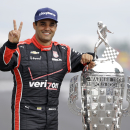 Juan Pablo Montoya, of Colombia, poses with the Borg-Warner Trophy during the traditional winners photo session at Indianapolis Motor Speedway in Indianapolis, Monday, May 25, 2015. Montoya won the 99th running of the Indianapolis 500 auto race on Sunday. (AP Photo/Michael Conroy)