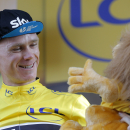 Britain's Chris Froome, wearing the overall leader's yellow jersey, is all smiles as he looks at the yellow jersey mascot equipped with a camera on the podium of the sixteenth stage of the Tour de France cycling race over 201 kilometers (124.9 miles) with start in Bourg-de-Peage and finish in Gap, France, Monday, July 20, 2015. (AP Photo/Christophe Ena)