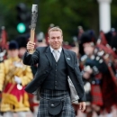 Olympic gold medal cyclist Chris Hoy carries the Commonwealth Games Baton along The Mall to Buckingham Palace in London October 9, 2013. REUTERS/Stefan Wermuth