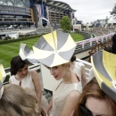 Umbrella hats worn by a singing group as they pose next to the parade ring on the second day of Royal Ascot horse racing meet at Ascot, England, Wednesday, June 17, 2015. Royal Ascot is the annual five day horse race meeting that Britain's Queen Elizabeth II attends every day of the event.(AP Photo/Alastair Grant)