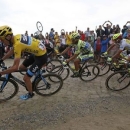 Team Sky rider Chris Froome of Britain (L), race leader and yellow jersey holder, and Tinkoff-Saxo rider Alberto Contador of Spain (C) cycle on a cobble-stoned section during the 223.5-km (138.9 miles) 4th stage of the 102nd Tour de France cycling race from Seraing in Belgium to Cambrai, France, July 7, 2015. REUTERS/Eric Gaillard