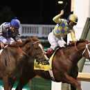 Jockey Shaun Bridgmohan, right, celebrates after guiding Noble Bird to a narrow victory over Lea, left, ridden by Joel Rosario, in the Stephen Foster Handicap horse race at Churchill Downs in Louisville, Ky., Saturday, June 13, 2015. (AP Photo/Garry Jones)