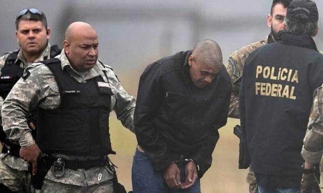 Adélio Bispo de Oliveira é escoltado por policiais no aeroporto de Juiz de Fora. (Foto: Ricardo Moraes/Reuters/08-09-2018)