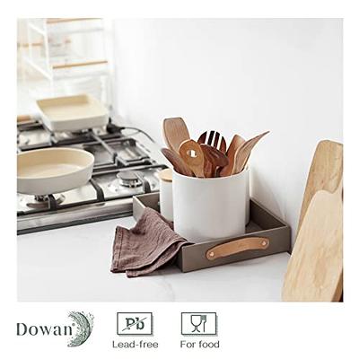 White ceramic utensils and kitchen utensils on a wooden countertop