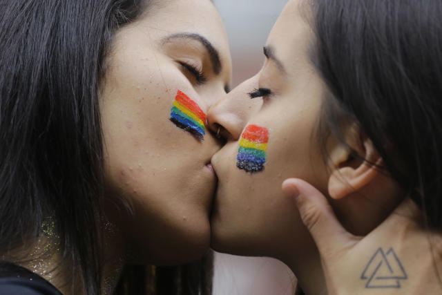 En esta imagen del 3 de junio de 2018, dos asistentes se besan durante el desfile anual del orgullo gay en Sao Paulo, Brasil. (AP Foto/Nelson Antoine)