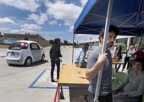 In this May 13, 2015 photo, Google co-founder Sergey Brin, right, speaks to reporters and guests about the new Google self-driving prototype car during a demonstration at the Google campus in Mountain View, Calif. The car, which needs no gas pedal or steering wheel, will make its debut on public roads this summer. (AP Photo/Tony Avelar)