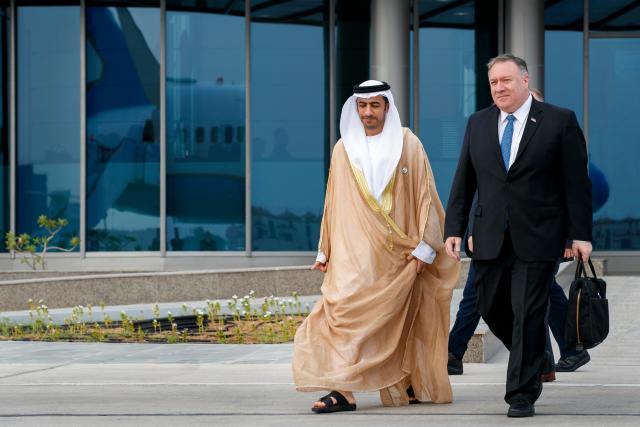 As his plane is reflected in the glass building behind them, Secretary of State Mike Pompeo, right, walks with Abu Dhabi Assistant Foreign Ministry Undersecretary for Protocol Affairs Shihad Al Faheem, as they say goodbye on the secretary's departure from Abu Dhabi, United Arab Emirates, Tuesday, June 25, 2019, en route to an undisclosed location.
