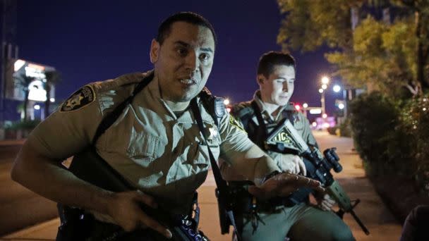 PHOTO: Police officers advise people to take cover near the scene of a shooting near the Mandalay Bay resort and casino on the Las Vegas Strip, Sunday, Oct. 1, 2017, in Las Vegas. (John Locher/AP)