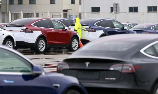 A worker walks next to Tesla cars at a port in Shanghai, China February 22, 2019. REUTERS/Stringer ATTENTION EDITORS - THIS IMAGE WAS PROVIDED BY A THIRD PARTY. CHINA OUT. - RC194EF18C30