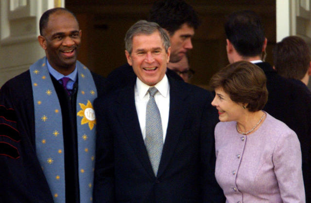 George W. Bush stands with his wife Laura and Rev. Kirbyjon H. Caldwell after services at Tarrytown United Methodist Church in Austin, Texas, on Dec. 14, 2000. Caldwell has long been a spiritual adviser to Bush.