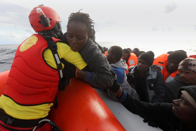 A lifeguard pulls a migrant woman to a rescue craft from an overcrowded raft in the central Mediterranean Sea, some 36 nautical miles off the Libyan coast, Jan. 2, 2017. (Yannis Behrakis / Reuters)